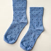 Pair of blue socks with black dots on a beige background