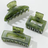 Three translucent green hair claws on a white background
