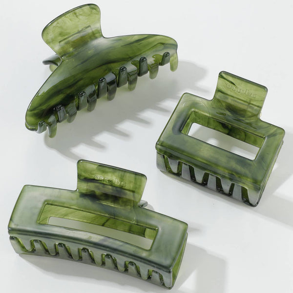 Three translucent green hair claws on a white background