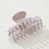 Marble-patterned purple and gold hair claw on a white background