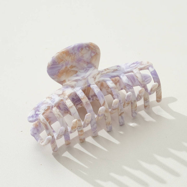 Marble-patterned purple and gold hair claw on a white background
