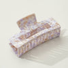 Large rectangular purple and gold swirled hair claw on white background.