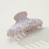Marbled purple and gold hair claw on a white background