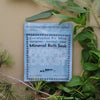 Pacific Coast Mineral Bath Soak packet surrounded by greenery on a beige background