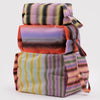 A stack of three expanding packing organizers in a colorful gradient stripe pattern.