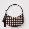 A nylon half moon crossbody bag with a blurry brown gingham pattern against a white background.