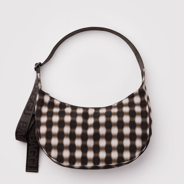 A nylon half moon crossbody bag with a blurry brown gingham pattern against a white background.