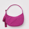 A bright fuchsia nylon half moon handbag against a white background.