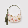 A small nylon crescent crossbody bag with an abstract cream, red, and green floral print and an olive green strap against a white background.