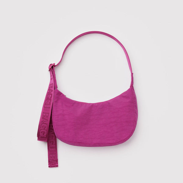A deep fuchsia small nylon crescent crossbody bag against a white background.