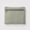 A sage green and white striped zipper pouch to fold away and store the Cloud Bag.