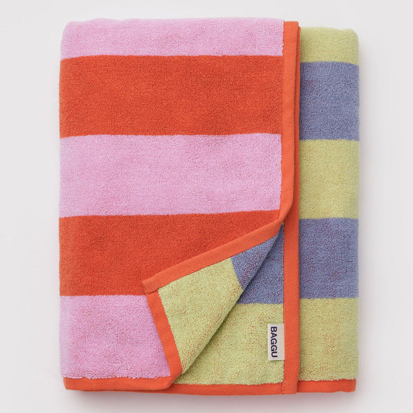 Colorful striped towel with a brand label folded on a light gray background