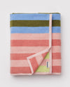 Folded striped towel with multicolor pattern on a light gray background