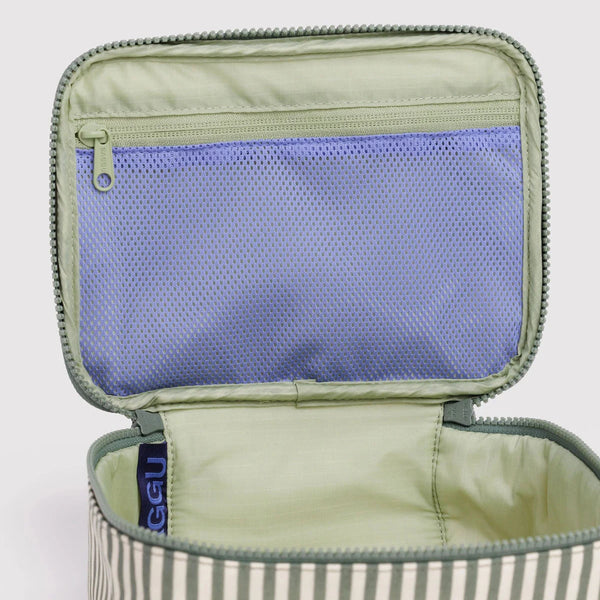 The interior of a sage green and white striped nylon cosmetic case. The interior is solid green with a blue mesh zipper pocket. 