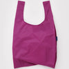 A nylon shopping bag in a deep fuchsia shade on a white backdrop.