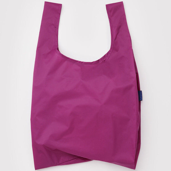 A nylon shopping bag in a deep fuchsia shade on a white backdrop.