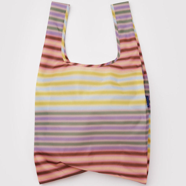A nylon shopping bag in a gradient muted multicolor stripe on a white backdrop.