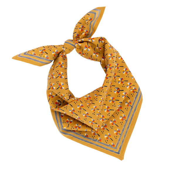 Yellow pinwheel patterned bandana on a white background