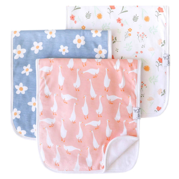 Three baby burp cloths with floral, goose, and botanical patterns on a white background.