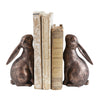 Bronze rabbit bookends holding books on a white background