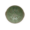 Green ceramic strainer berry bowl on a white background