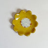 Yellow ceramic flower-shaped dish on a white background