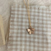 Butterfly pendant necklace on a checkered fabric background