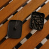 Black incense burner with smoke on a wooden surface