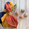 Colorful textured cloths with woven rings on a wooden surface