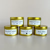 Five gold-tinted candles with labels on a light gray background