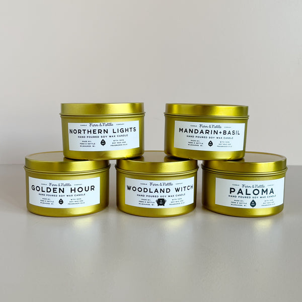 Five gold-tinted candles with labels on a light gray background