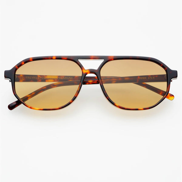 Sunglasses with tortoiseshell frame and gold lenses on a white background