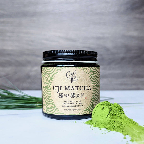 Jar of Uji Matcha green tea powder with a gray background