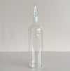 Clear glass bottle with a long spout on a light gray background