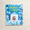 'Home is a Hug' illustrated children's book by Cindy Wume on a neutral background.
