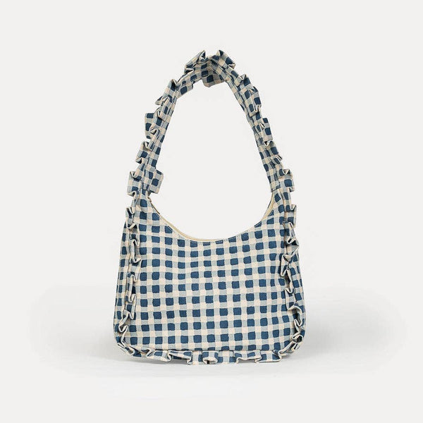 Blue and white checkered handbag with frill edge details on a white background
