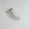 Clear lay-flat hair claw on beige background.