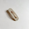 Tan flat hair claw on beige background.