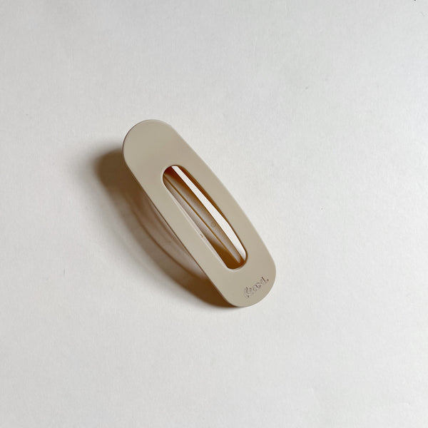 Tan flat hair claw on beige background.