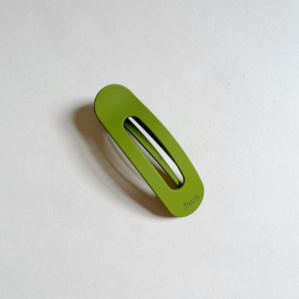 Bright green lay-flat hair claw on beige background.