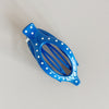 Blue hair clip with white polka dots on a light gray background