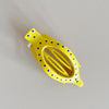 Yellow hair clip with blue dots on a light gray background
