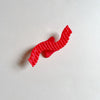 Wavy red hair claw on beige background.