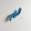 Wavy blue hair claw on beige background.