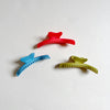 Three colorful wavy hair claws on beige background.