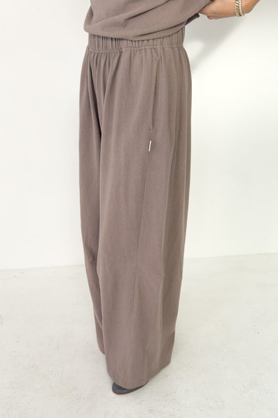 Brown wide-leg pants worn by a person on a white background
