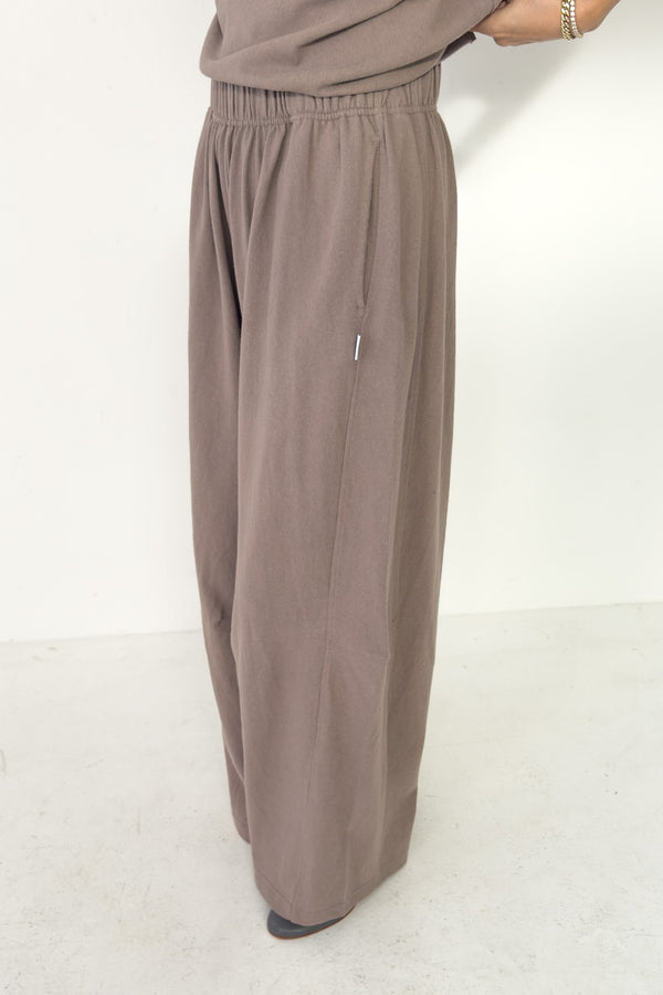 Brown wide-leg pants worn by a person on a white background