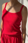 Red pointelle knit tank top worn by a person against a neutral background
