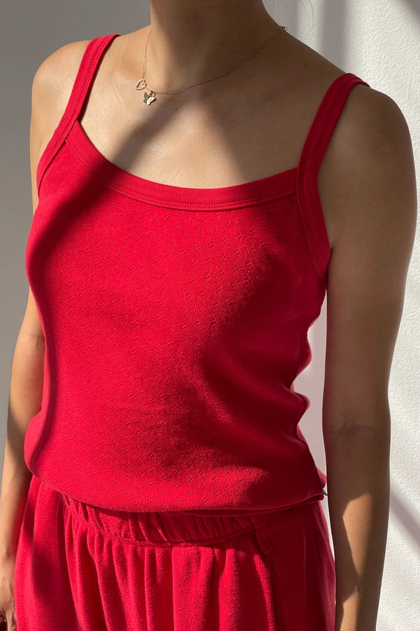 Red pointelle knit tank top worn by a person against a neutral background