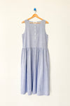 Blue and white striped cotton sleeveless dress on a wood hanger against a white wall.